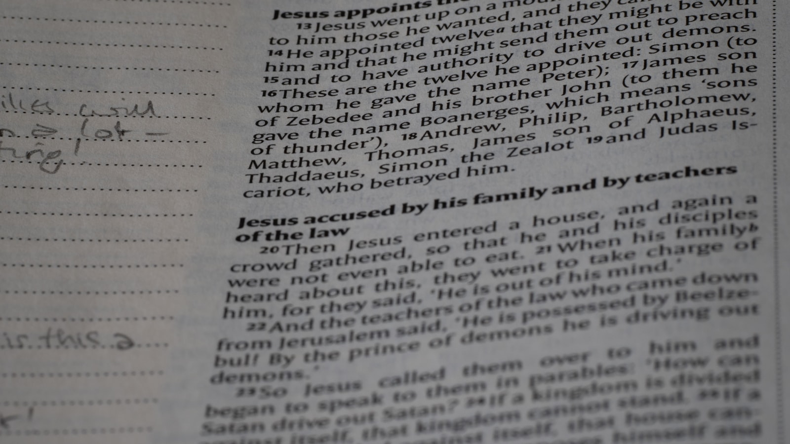 A student's desk scattered with a half-read textbook, a notebook covered in arrows and diagrams, and a single lamp casting focused light.
