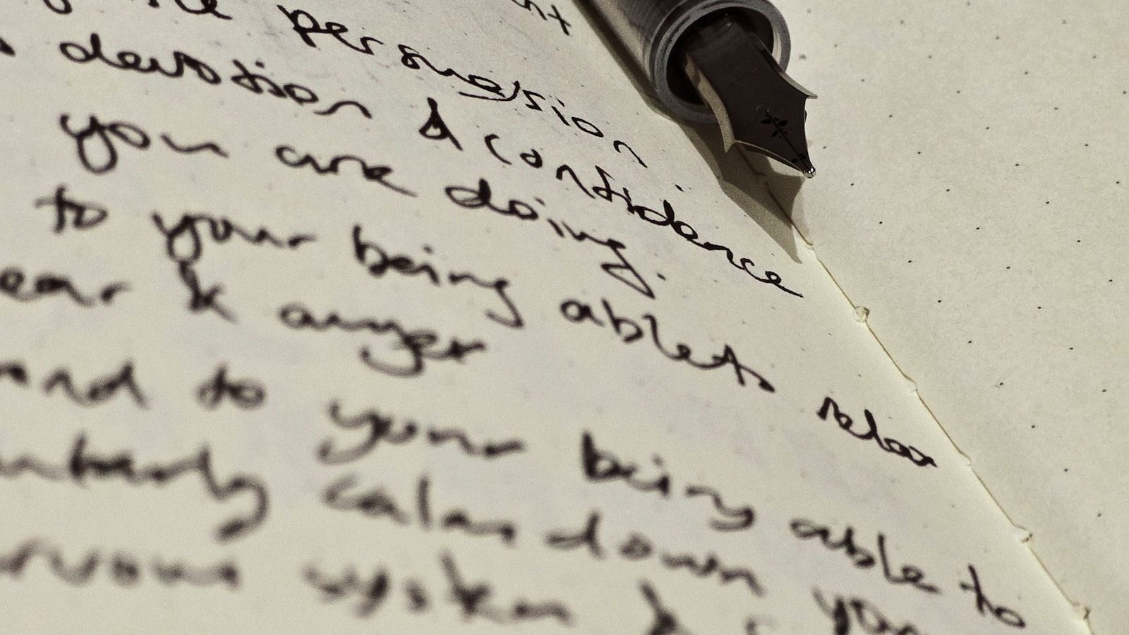 A student at a desk with several open textbooks, a page of handwritten notes, and crossed-out scribbles under focused desk light.