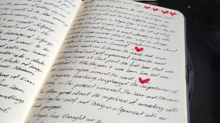 A printed manuscript marked up with marginal notes and numbered paragraph summaries on a wooden desk beside a mug and a red pen.
