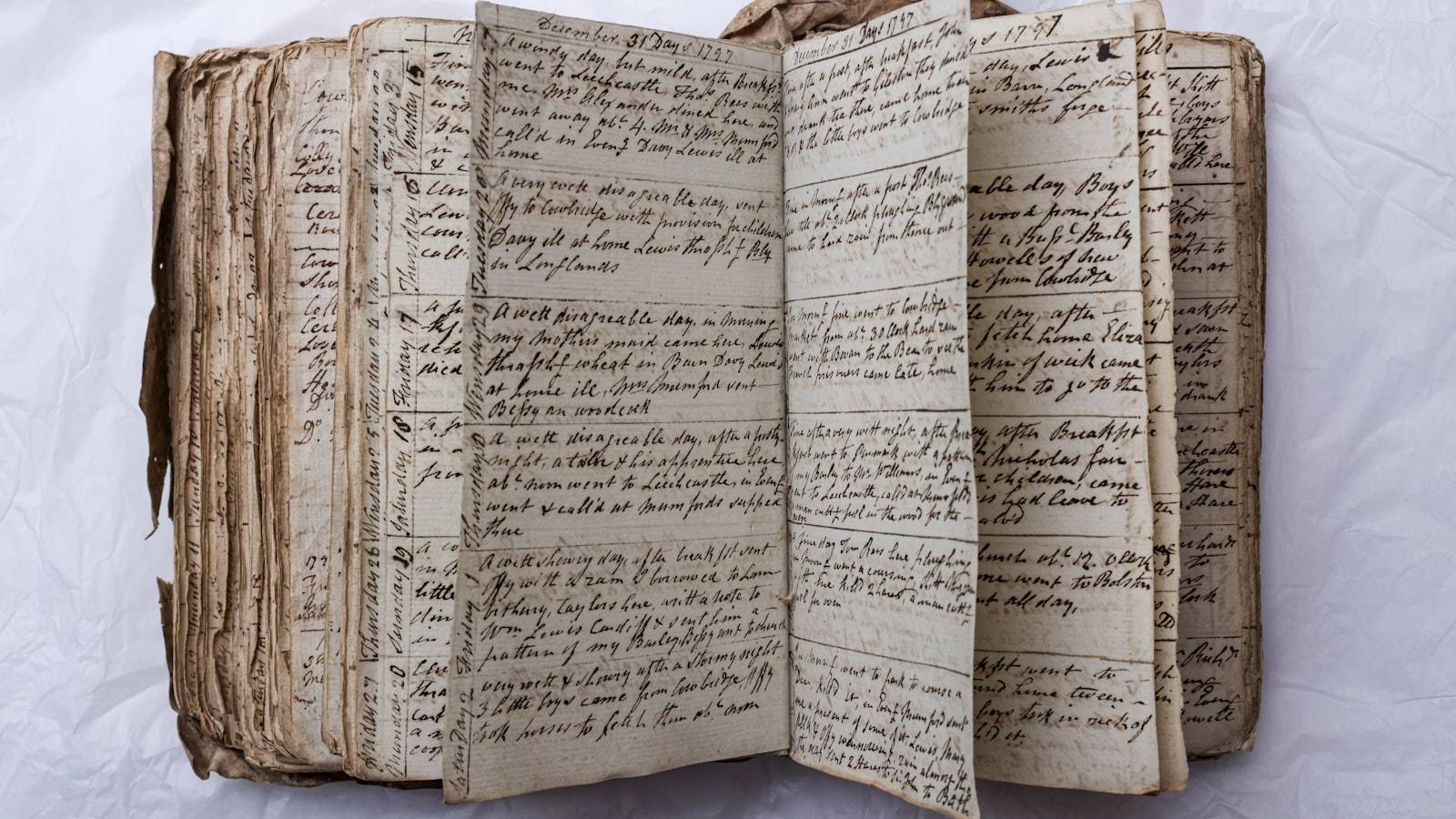 A stack of worn flashcards scattered on a wooden desk next to an open notebook and a cup of black coffee.